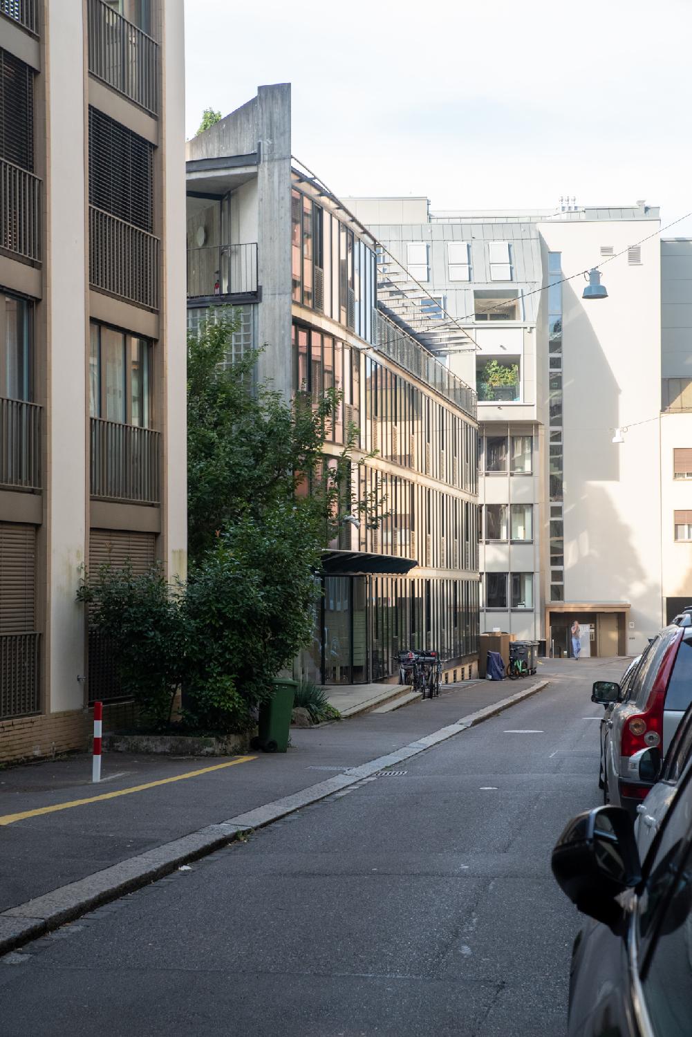 Alte Feldeggstrasse in Zürich: a narrow street with cars parked on the right and 4-5-story buildings all around.