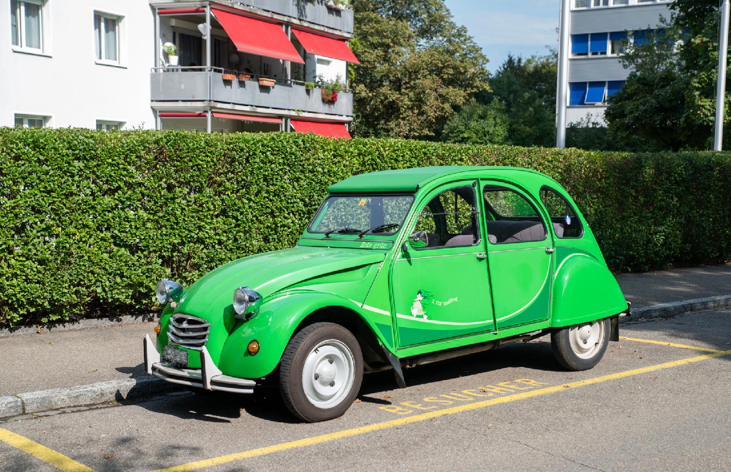 A green Citroën 2CV with a sticker "I fly bleifrei" on the side