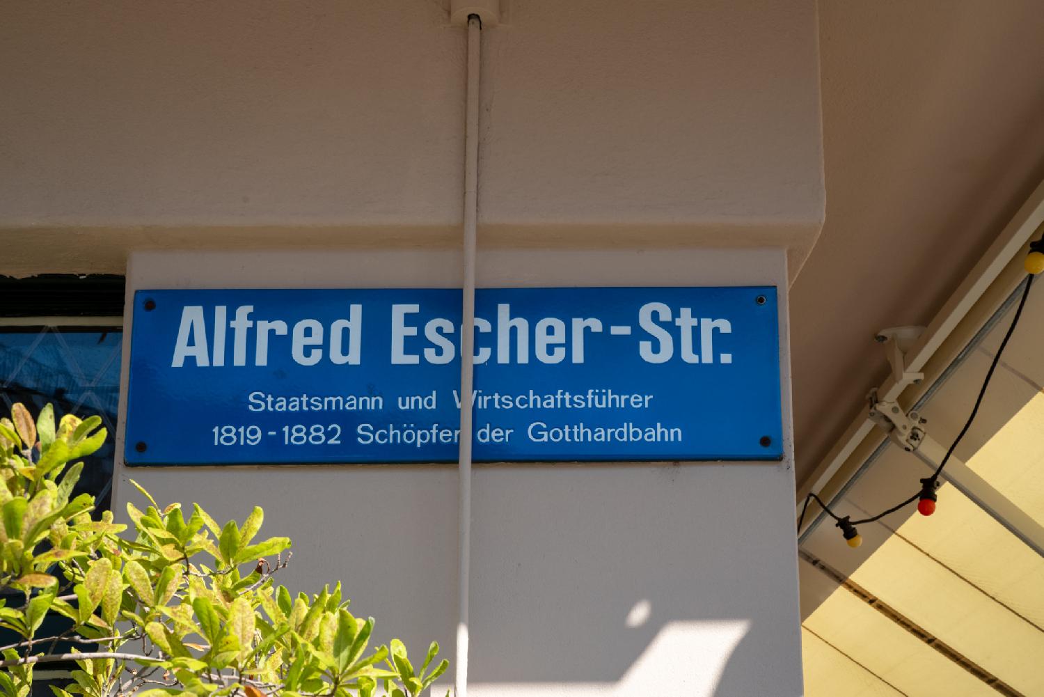 Alfred-Escher-Strasse street sign in Zürich: a blue street name sign on a wall.