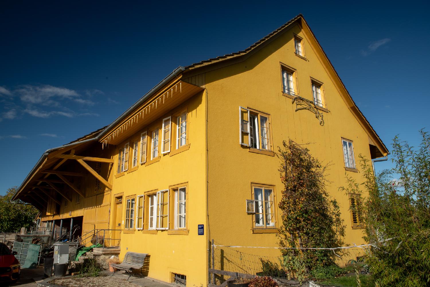Zürich Alte Mühlackerstrasse 14 - a large yellow house with a barn on its side