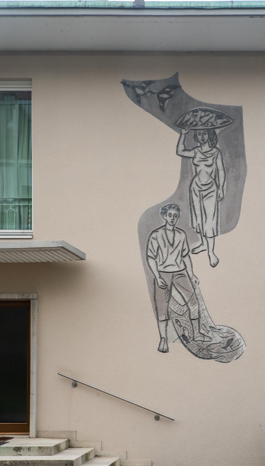 A mural in shades of grey on a residential builing: on top, two geese; in the middle, a woman with a fish platter on her head; at the bottom, a man with a full fishing net.