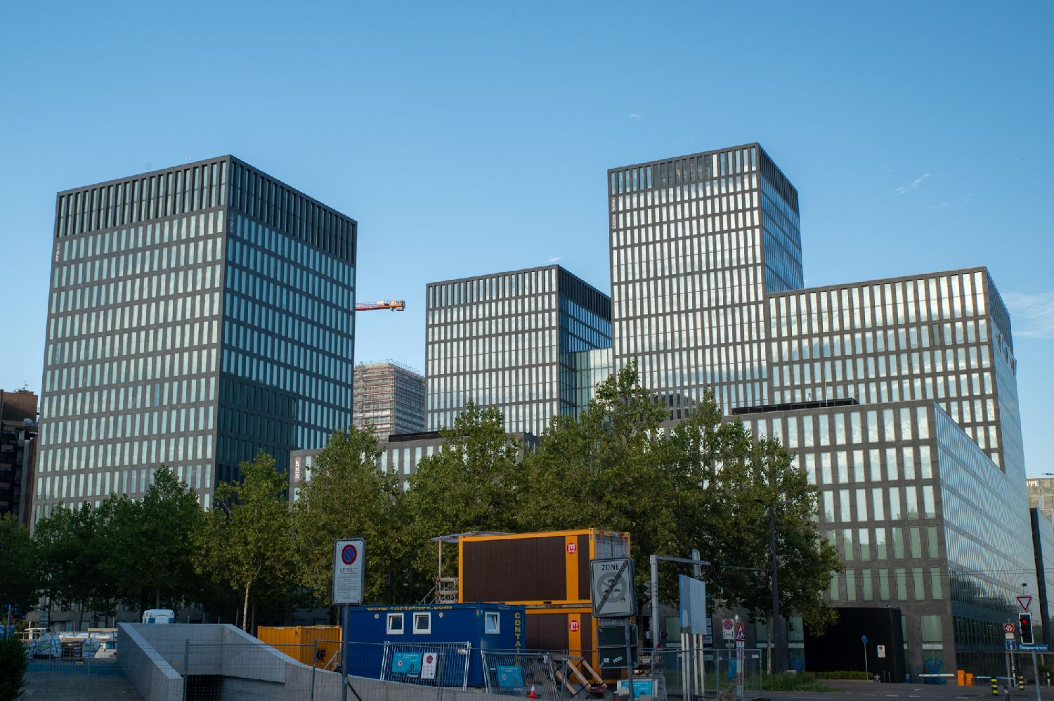 A set of similar-looking glass high-rises, with construction work in the foreground.