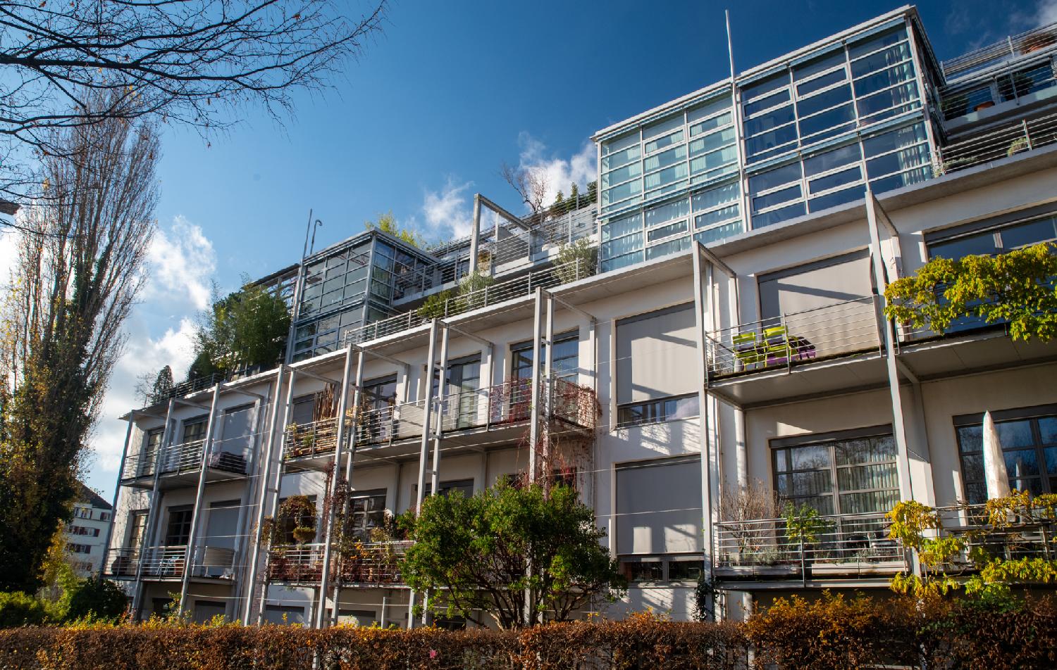 A four-story building with protected balconies and glass verandas on top