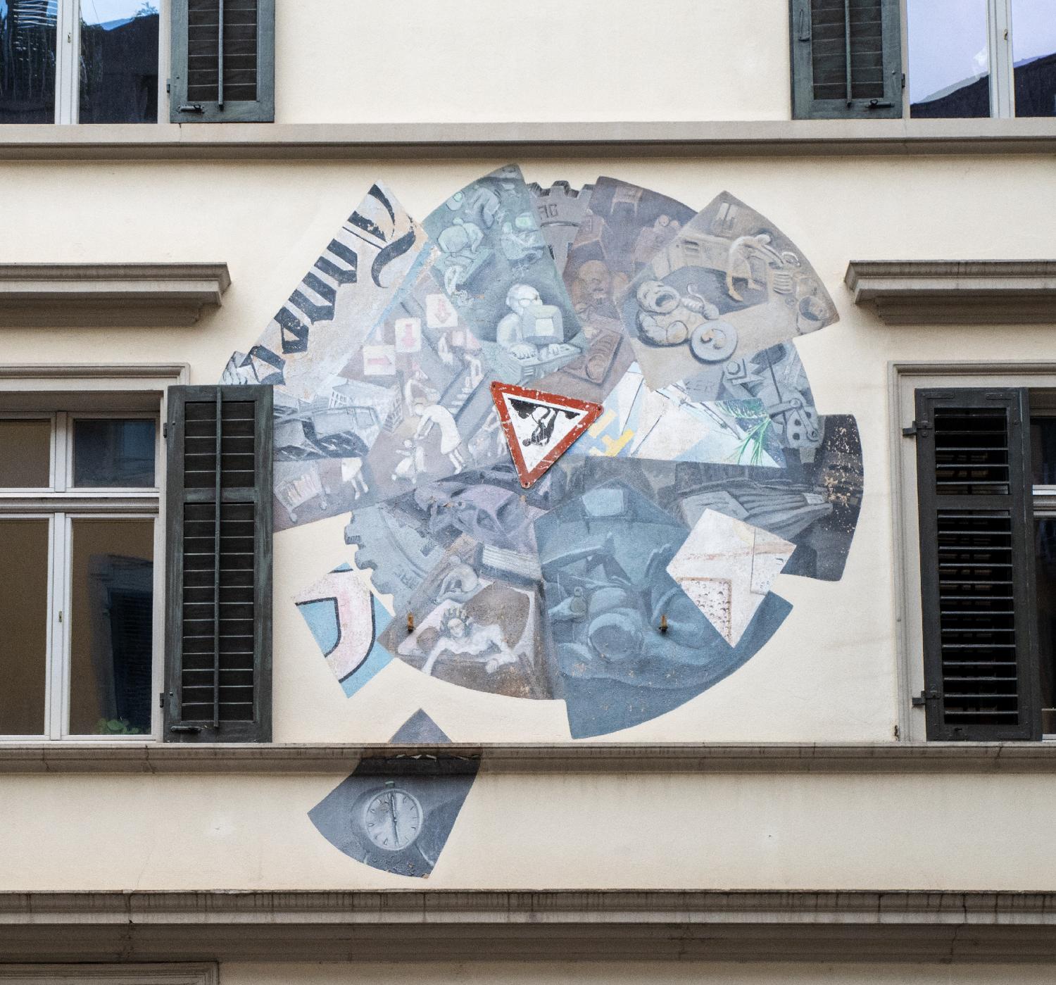 A circular blue/brown mural between two windows. There's an upside down "public works" sign in the middle of it, and the start of the TagesAnzeiger logo on the left.