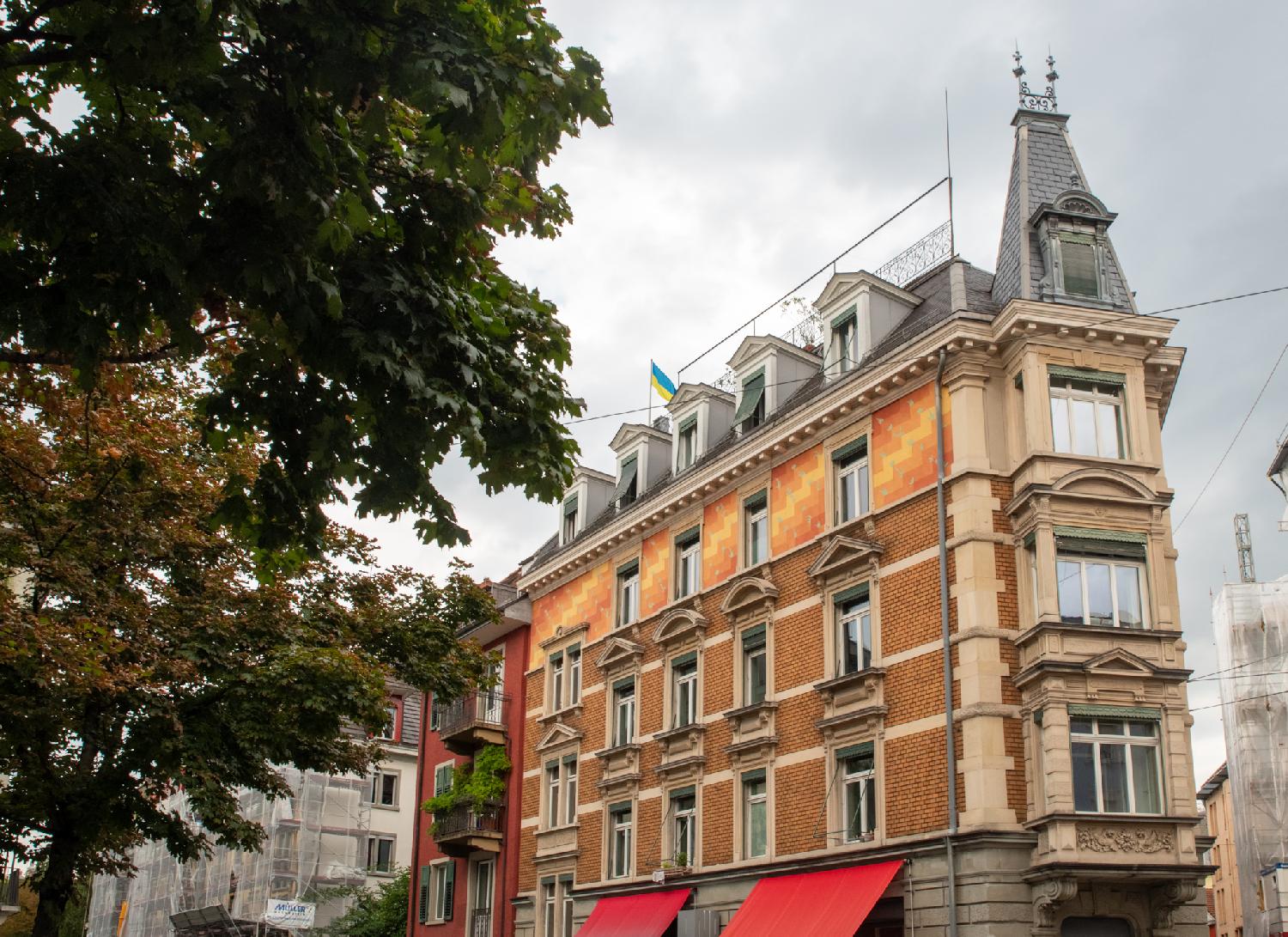 A 4-story building with painted tiles decorating the last floor