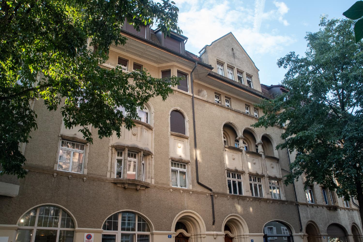 An ornate building with oriel windows and arches.