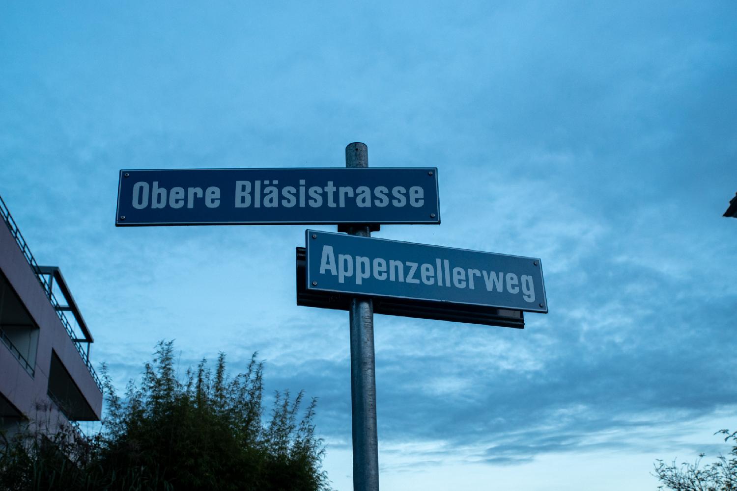 Blue street signs on a metal pole for Obere Bläsistrasse (on the left) and Appenzellerweg (on the right)