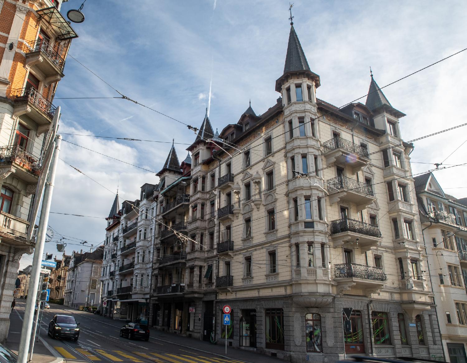 A 6-story residential building with bay windows and spires on each corner