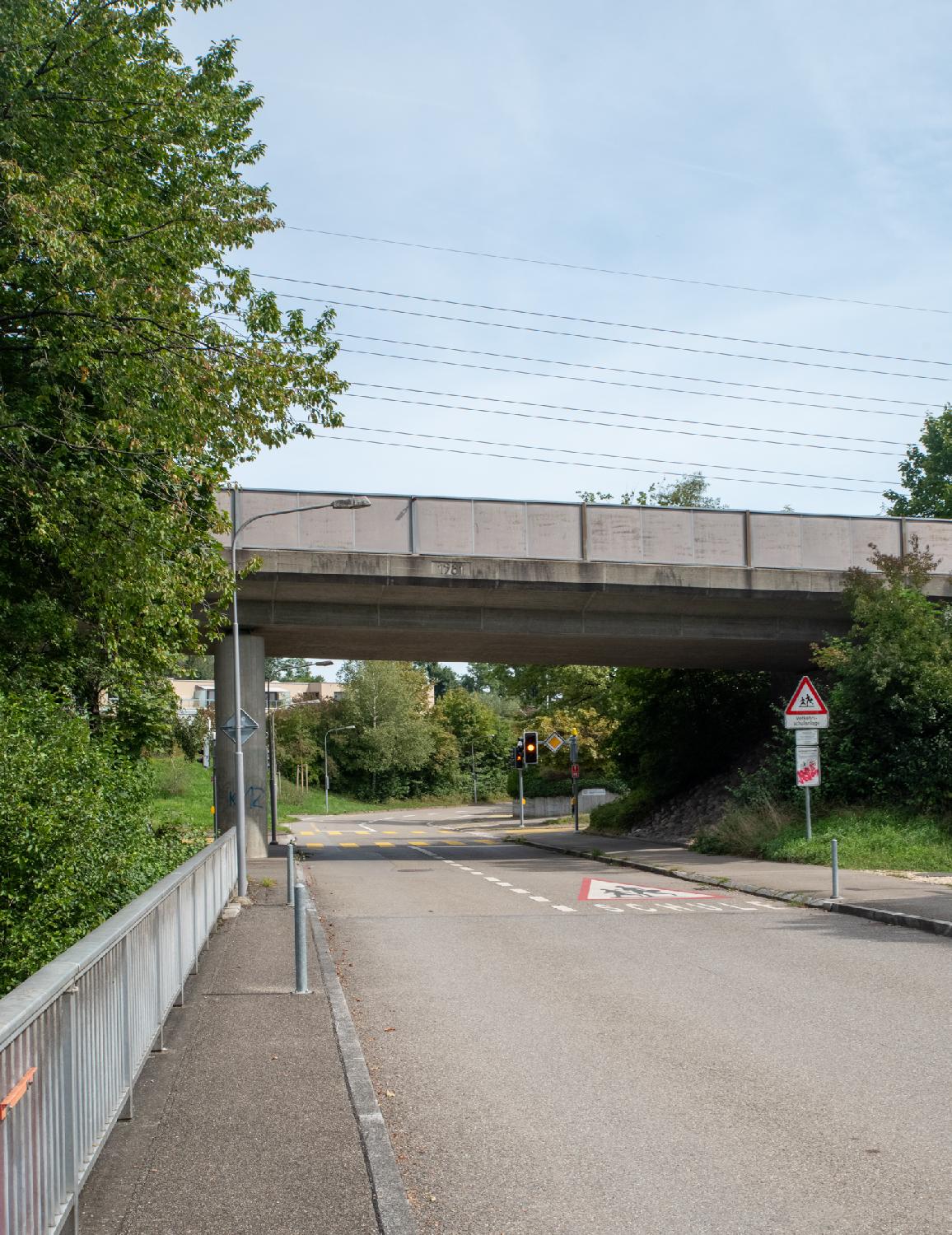 A two-way street on a bridge, with another bridge for a larger road above it