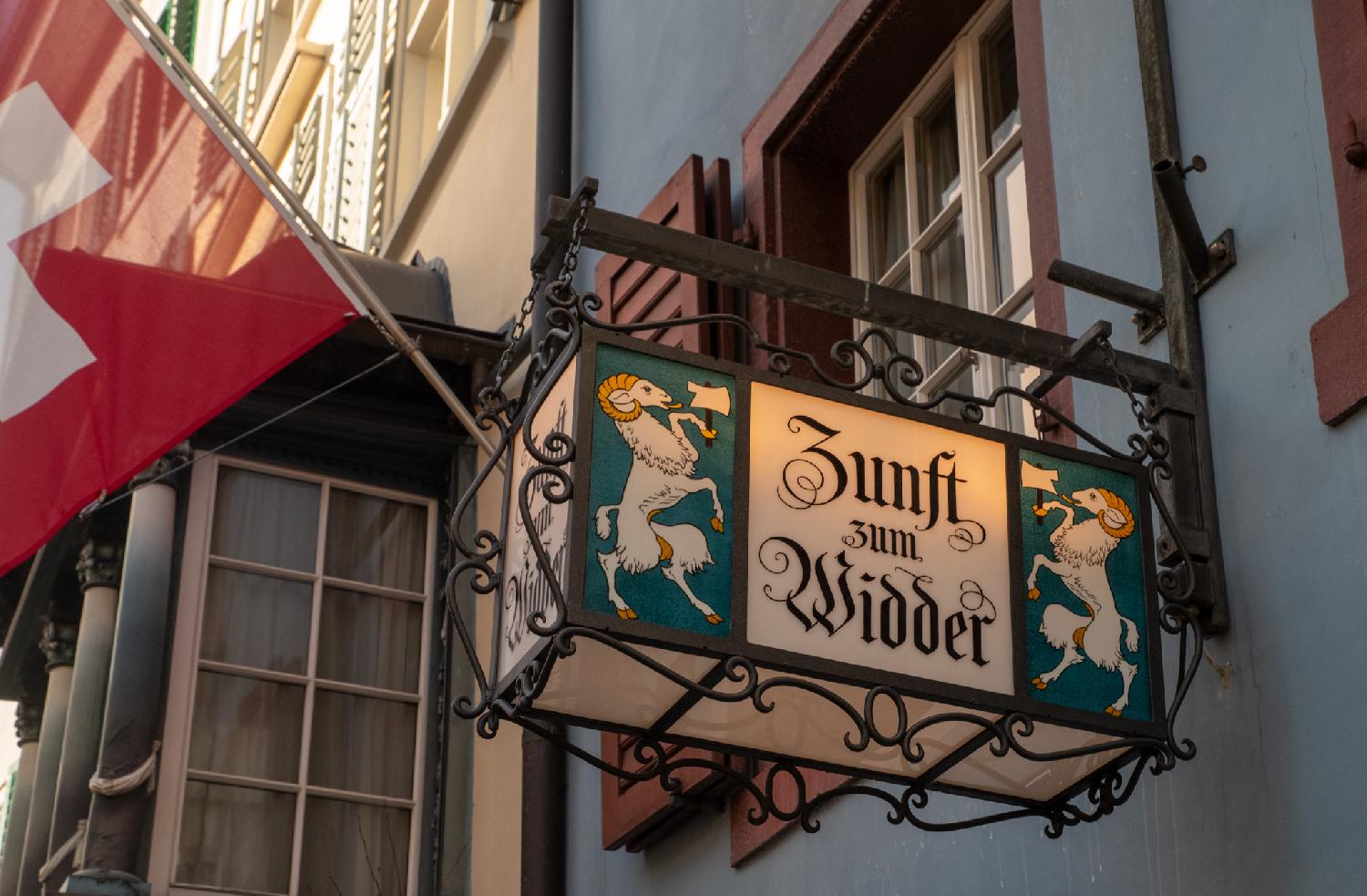 A house sign showing "Zunft zum Widder" with, on each side, a ram with a cleaver.