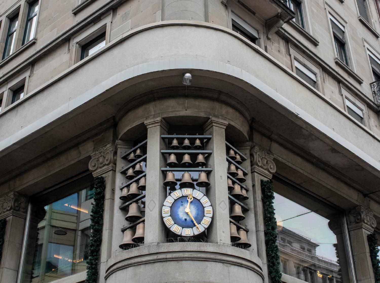 A carillon with 29 bells - 10 on each side, and 9 above a clock with a blue face and golden roman numbers and hands